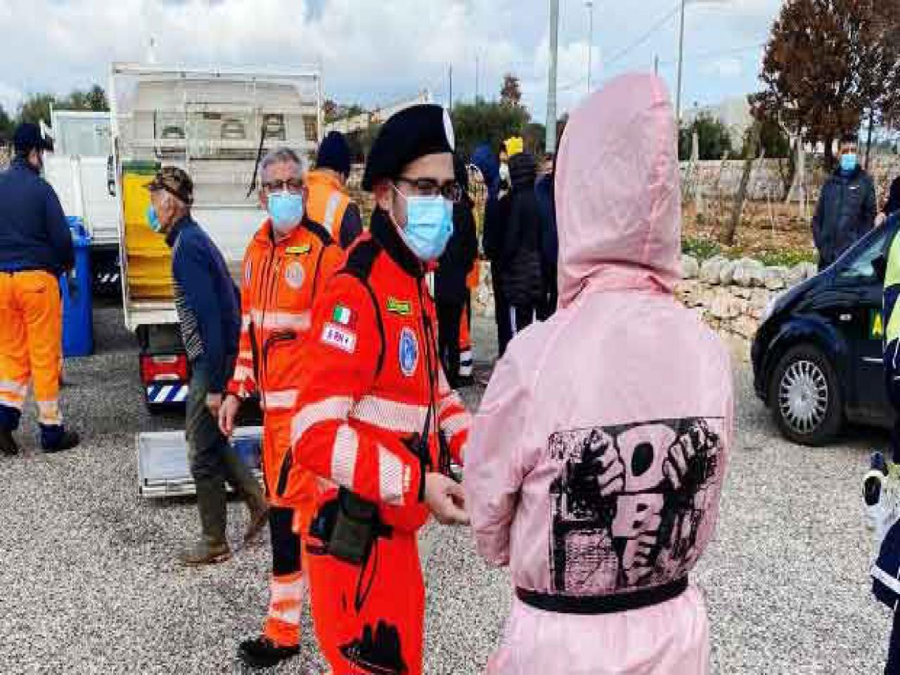 Uomo della protezione civile e ragazzina con cappuccio